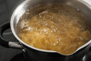Cooking pasta in pot on stove, closeup view