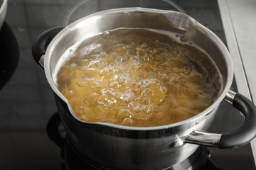 Cooking pasta in pot on electric stove