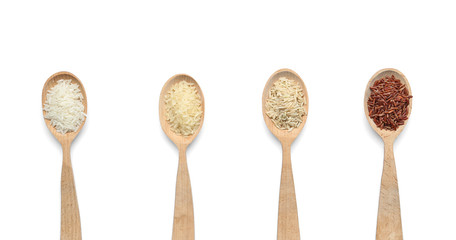 Spoons with different types of uncooked rice on white background, top view