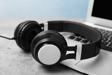 Obraz na płótnie Canvas Modern headphones and laptop on table, closeup