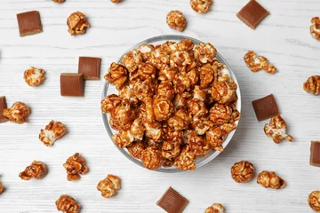 Poster Im Rahmen Flat lay composition with caramel popcorn on white wooden background © New Africa