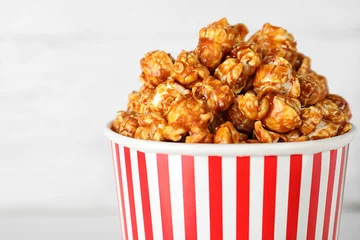 Foto op Canvas Paper cup with caramel popcorn on light background, closeup © New Africa