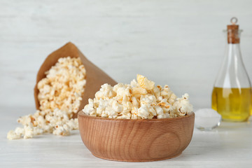 Wooden bowl with tasty popcorn on table