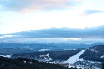 Fototapeta na wymiar Beautiful mountain landscape with forest and ski resort in winter