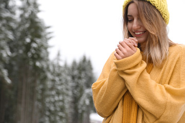 Young woman in warm clothes outdoors, space for text. Winter vacation