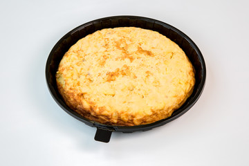 potato omelet on a black tray with white background