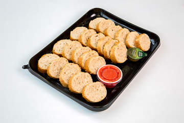 bread and tomato on a black tray with white background
