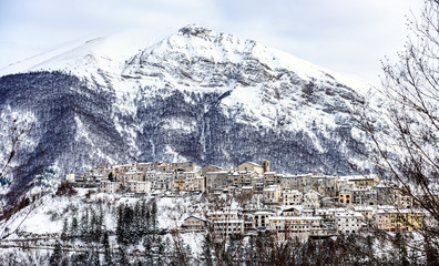 Aerial view of the beautiful snow-covered village of Opi with snow-capped mountains in the...
