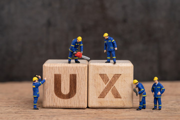 User Experience design in product and service concept, miniature people workers with blue team...