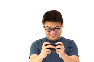 Portrait of an excited Asian man in dark blue t-shirt and wearing glasses playing games on mobile phone isolated over white background