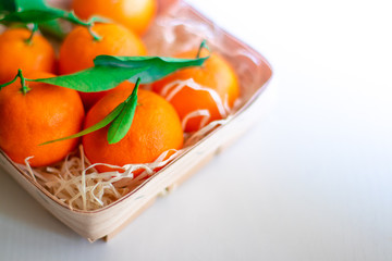Tangerines with green leaves in a basket 