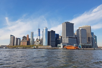 View of the island from the Hudson River on the port with moored ships and skyscrapers on the horizon. Office buildings from the river in New York