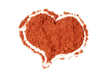 Red ground paprika in the shape of a heart isolated on white background, top view