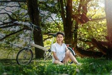 asian female taking rest after biking in park