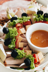 Set of skewer canapes and sauce on plate 