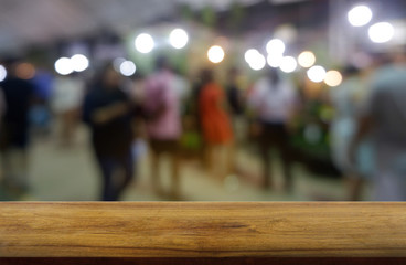 Empty dark wooden table in front of abstract blurred background of restaurant, shopping mall and people walking. can be used for display or montage your products - Image.