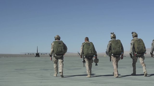 Slow motion of soldiers preparing to board military plane