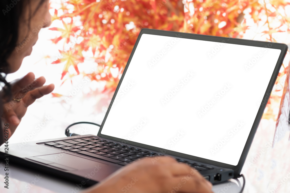 Wall mural blurred women looking blank screen display on laptop with blurred red maple leaf for mock up templated