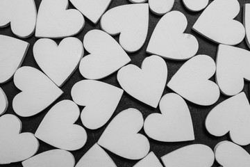 White wooden hearts on black background. Valentines pattern.