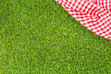Red checkered tablecloth background with green grass bokeh, copy space, mock up