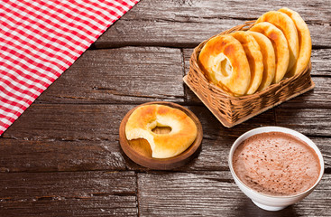 Pandequeso traditional Colombian food - Hot drink chocolate. Wood background