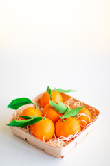 Tangerines with green leaves in a basket 