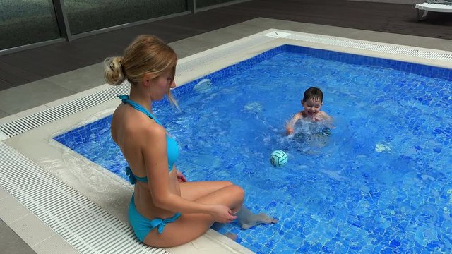 Young woman with little boy in swimming pool in sports club