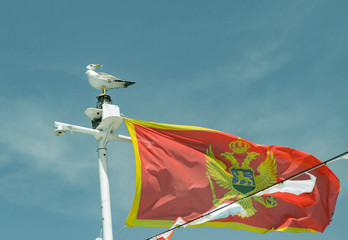 flag on background of blue sky in boka kotor bay in montenegro