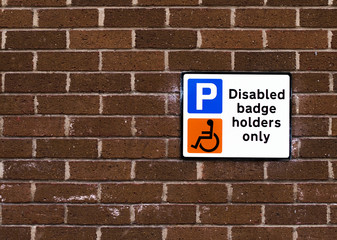 Fototapeta na wymiar Disabled badge holders only sign on a brick wall