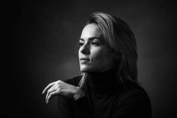 Dramatic black and white portrait of a beautiful woman on a dark background
