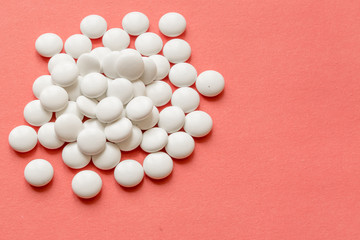 Fototapeta na wymiar White pills on pink background