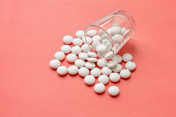 White pills on pink background