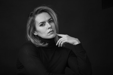 Dramatic black and white portrait of a beautiful woman on a dark background