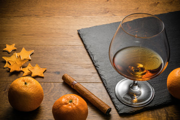 Glass of cognac and cigar with snack on the wood table with stone cutting board. Top view with copy space