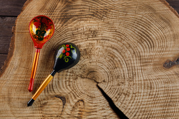 Two wooden spoons with a traditional Russian pattern on a wooden background. Khokhloma painting.