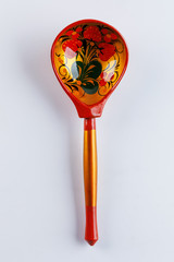 A wooden spoon handmade with a painting in the Russian style of Khokhloma.