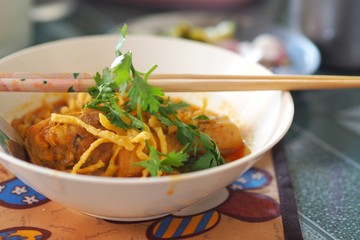 Khao Soi Gai or Northern Thai Coconut Curry Noodle Soup With Chicken with chopsticks.