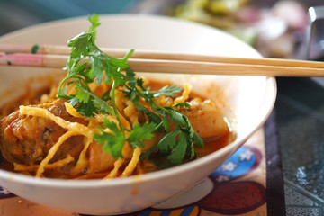 Khao Soi Gai or Northern Thai Coconut Curry Noodle Soup With Chicken with chopsticks.