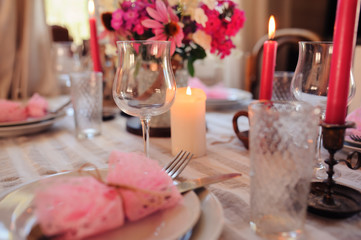 romantic summer dinner in cozy country house. Festive table setting with flowers and candles in purple tones