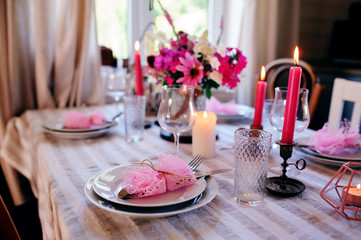 romantic summer dinner in cozy country house. Festive table setting with flowers and candles in purple tones