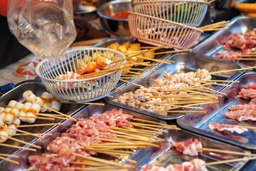 Raw meat beef pork chicken Sausage in wooden stick - street food.