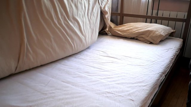 slow motion close view guy hands shake beige blanket twice spreading over double bed in cozy bedroom on nice day
