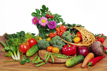 Vegetables and flowers on a wooden table. Cabbage, pepper, tomato, cucumber, onion, pea