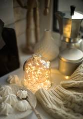 Cozy winter interior styling and decor, warm string lights in bell jar