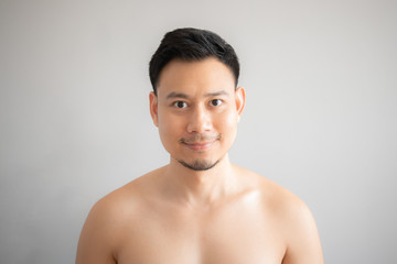 Fototapeta na wymiar Smile Asian man in topless portrait isolated on gray background.