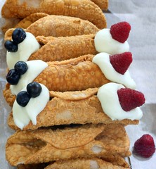 Sicilian pastry called cannolo stuffed with cream and berries