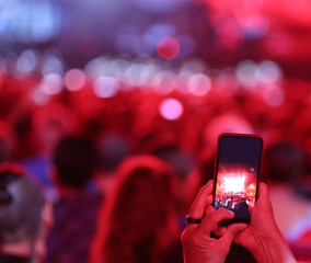 viewer photograps with the mobile phone the performance of a singer