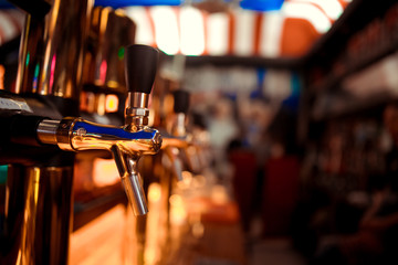 Hand of bartender pouring a large lager beer in tap.