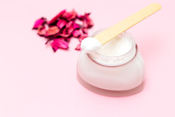 Fototapeta na wymiar Glass jar of cream on pink background. Skin care