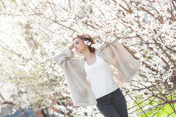 Close up portrait of young beautiful woman on spring background. Attractive young girl with flowers. Spring make up model.